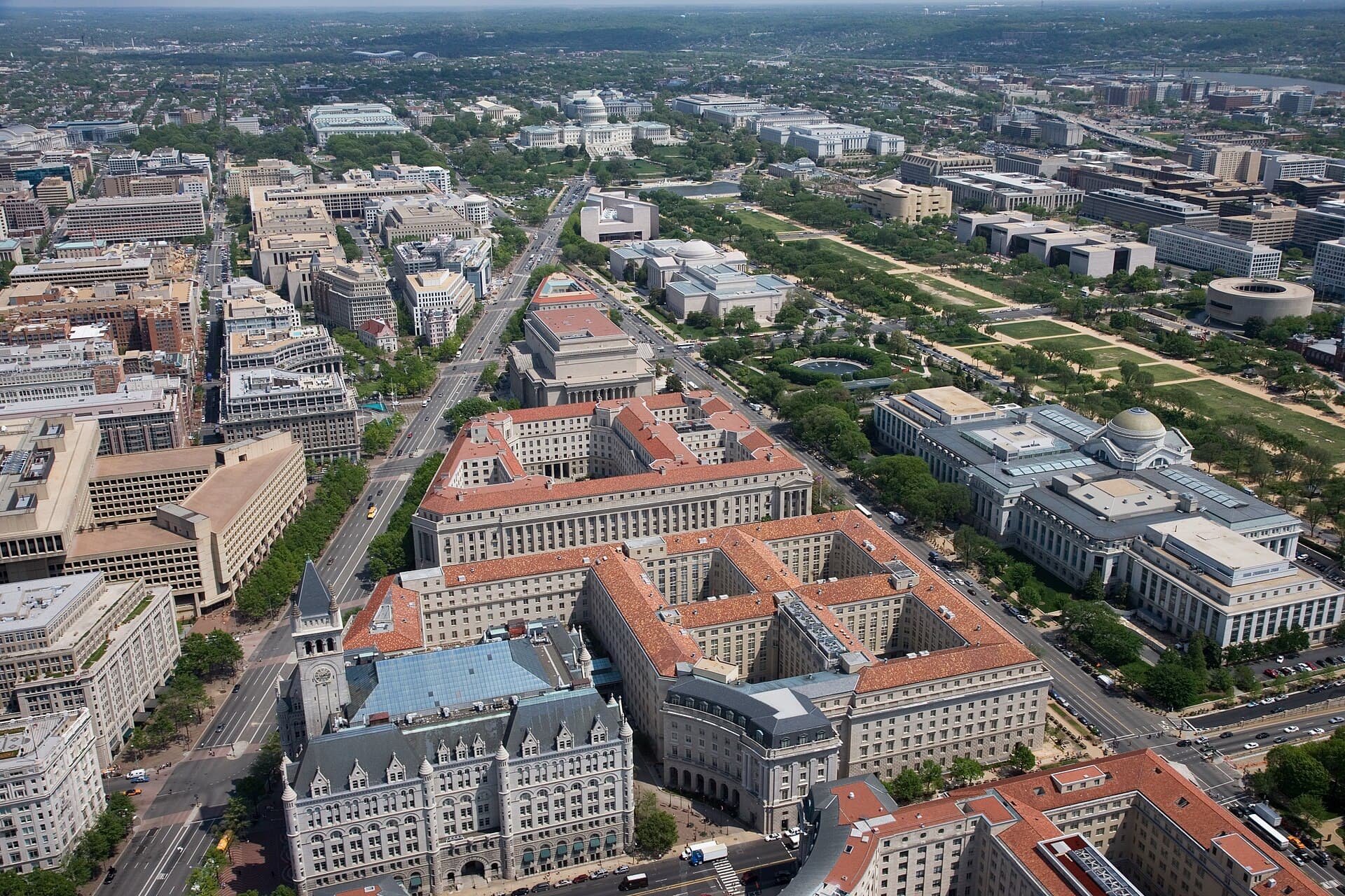 Aerial view of Pennsylvania Avenue (left) and the Federal Triangle (center) , facing east towards the United States Capitol in Washington, D.C. Visible landmarks include the Old Po