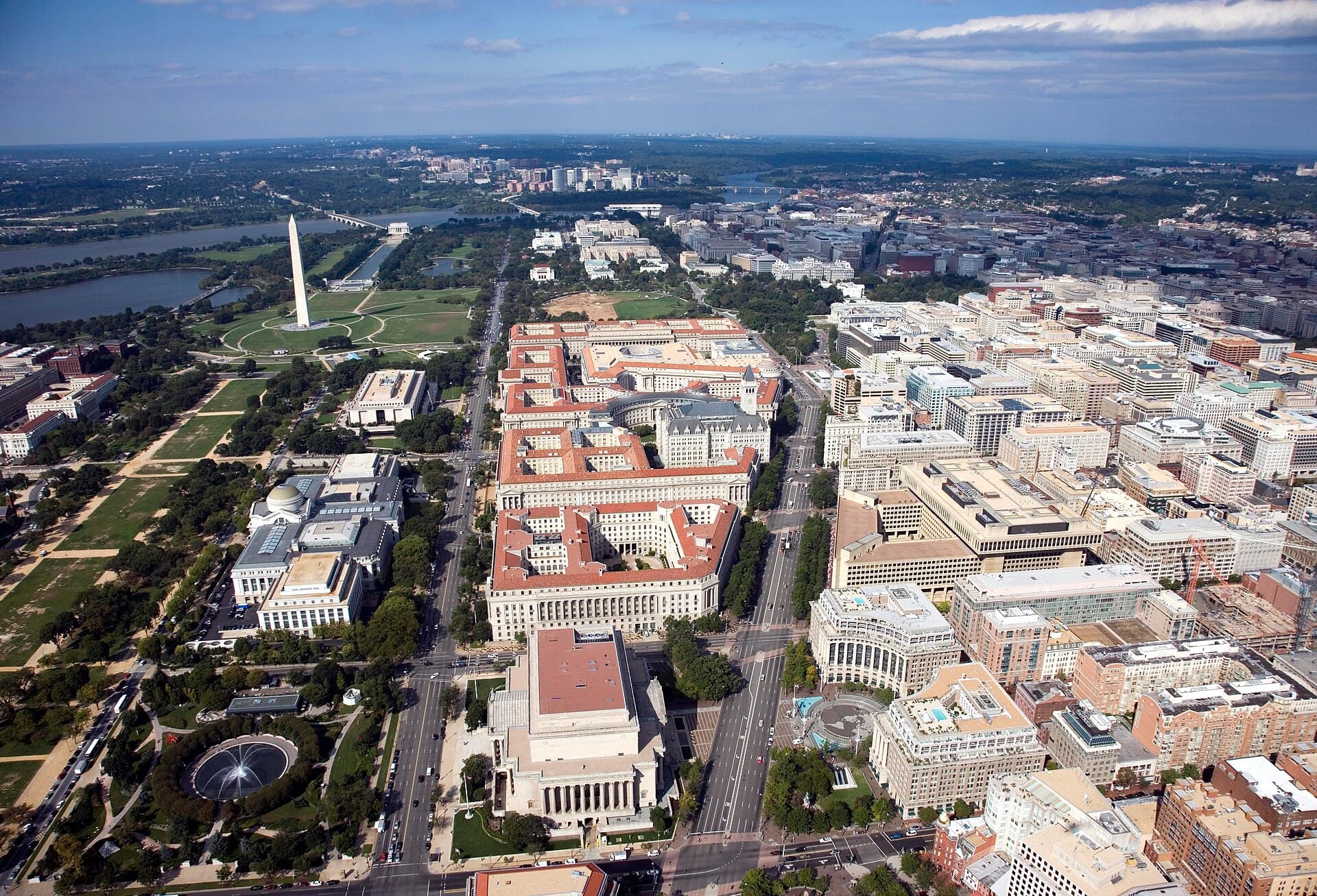 Aerial view of Pennsylvania Avenue (center right) and the Federal Triangle (center) – facing west towards Arlington County , Virginia – in Washington, D.C. Visible landmarks includ