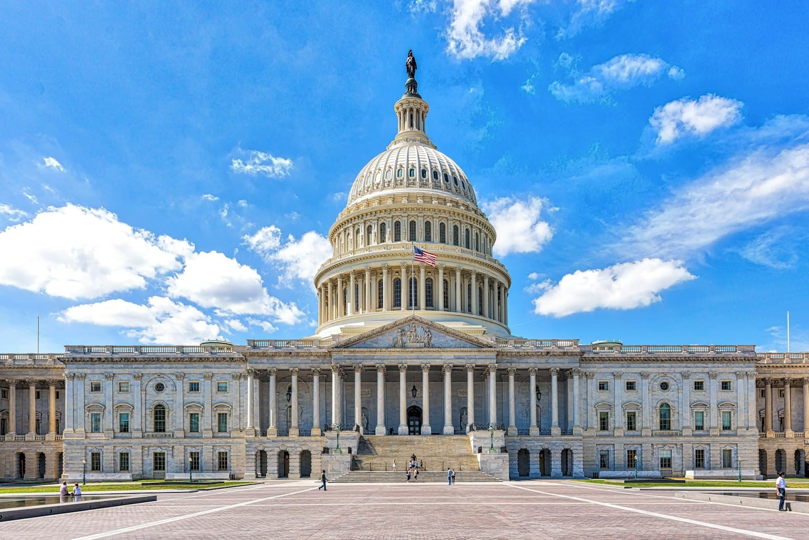 a large building with a dome and a flag on top with United States Capitol in the background