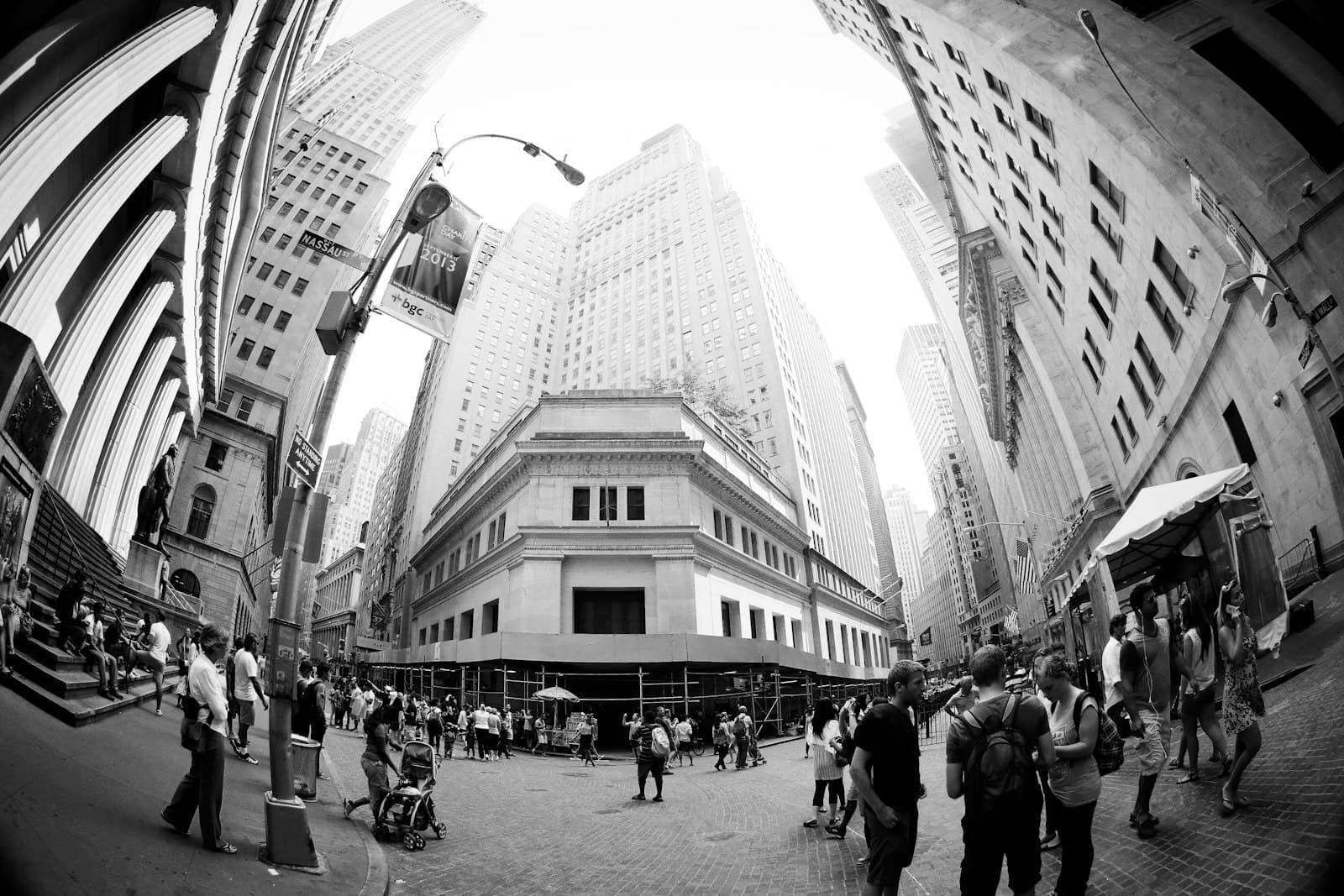 People walk through a bustling city street with tall buildings